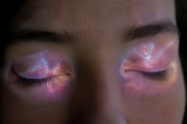 Yeux fermés avec des lumières subtiles, explorant la signification spirituelle des phosphènes.