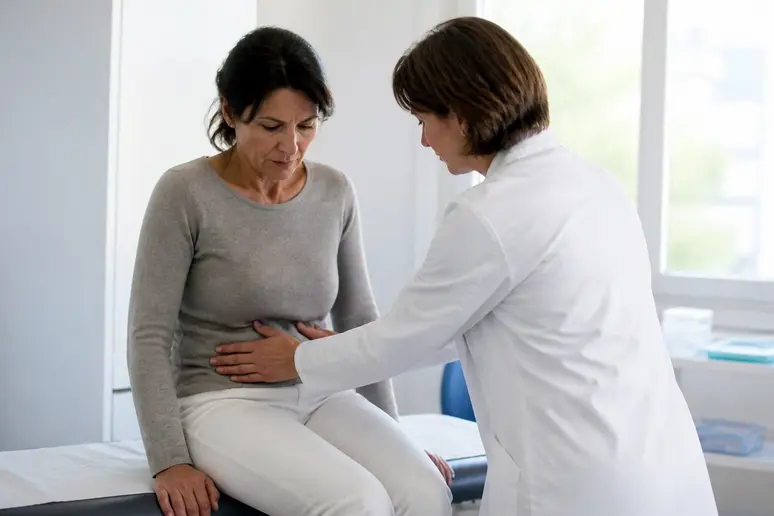 Médecin examinant une douleur à la fosse iliaque droite chez une patiente.